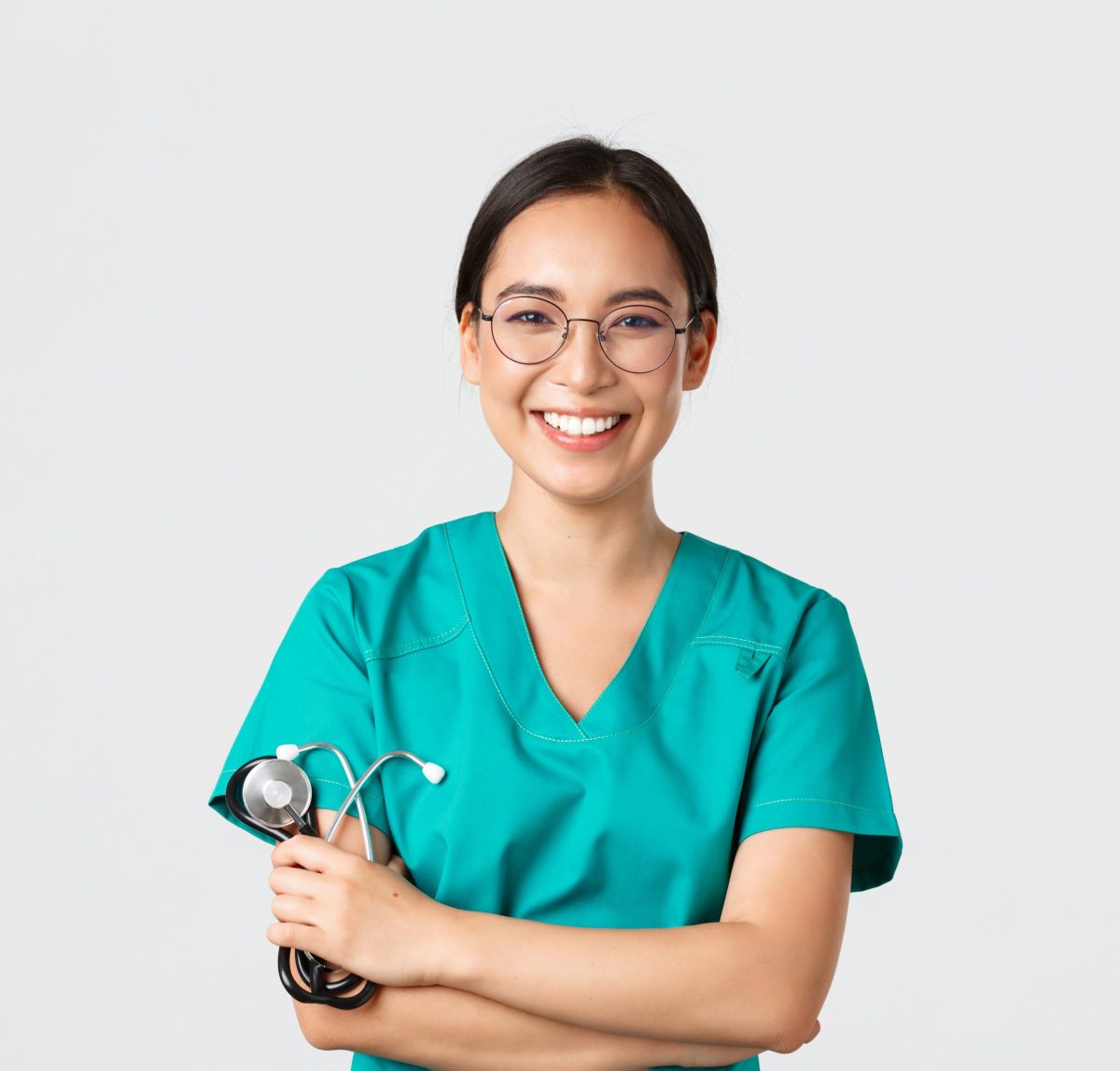 A imagem apresenta uma médica de origem asiática, vestindo uniforme de médica, segurando o estetoscópio de braços cruzados em frente ao fundo cinza