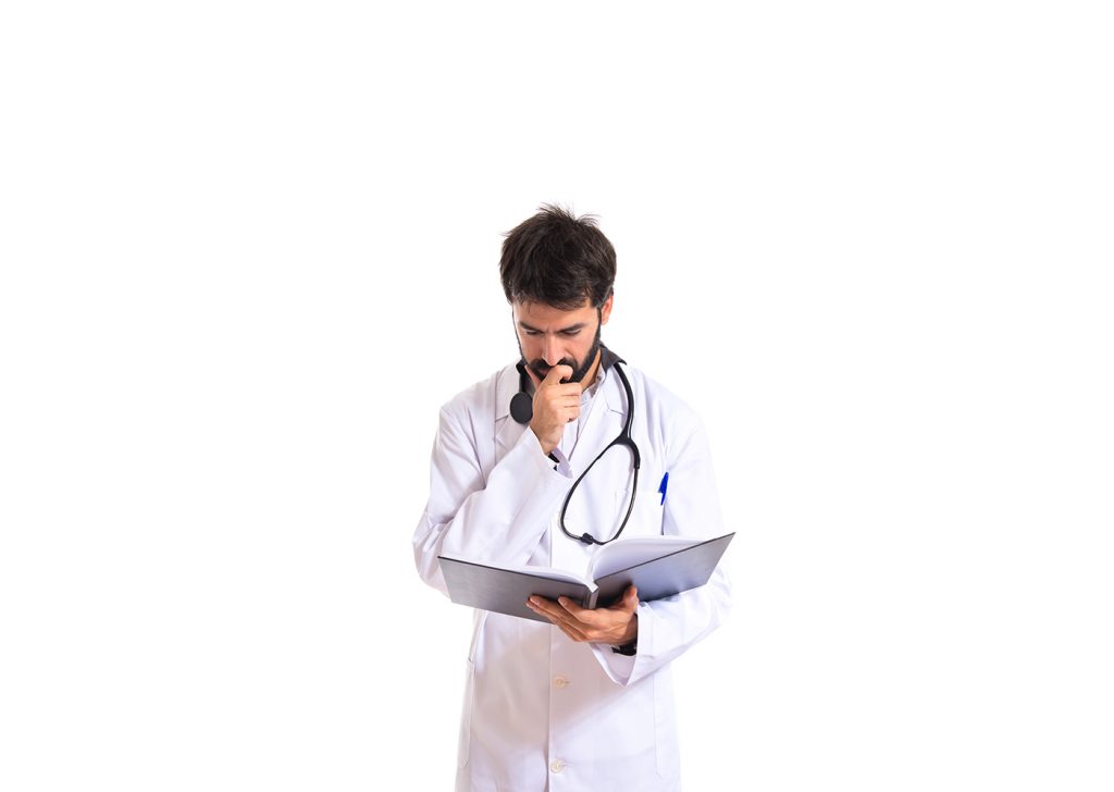 A imagem apresentada um médico estudando uma prancheta com a mão no queixo pensativo, ele está em frente ao fundo branco.
